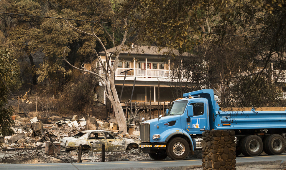 A PG&E truck drives through a Sonoma County, California, neighborhood devastated by fires